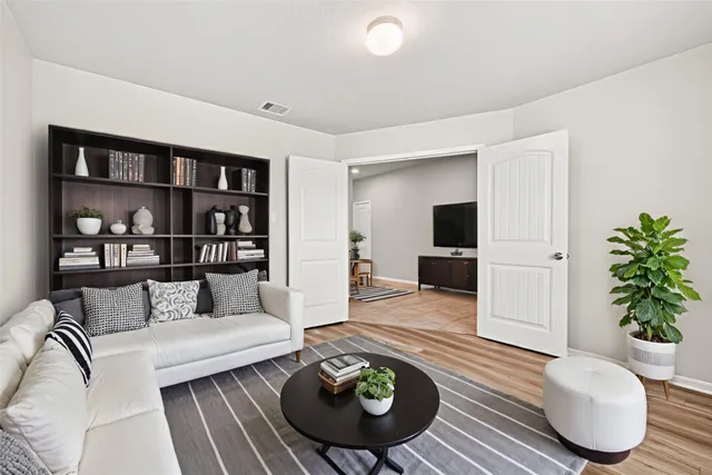 a living room with furniture and a wooden floor