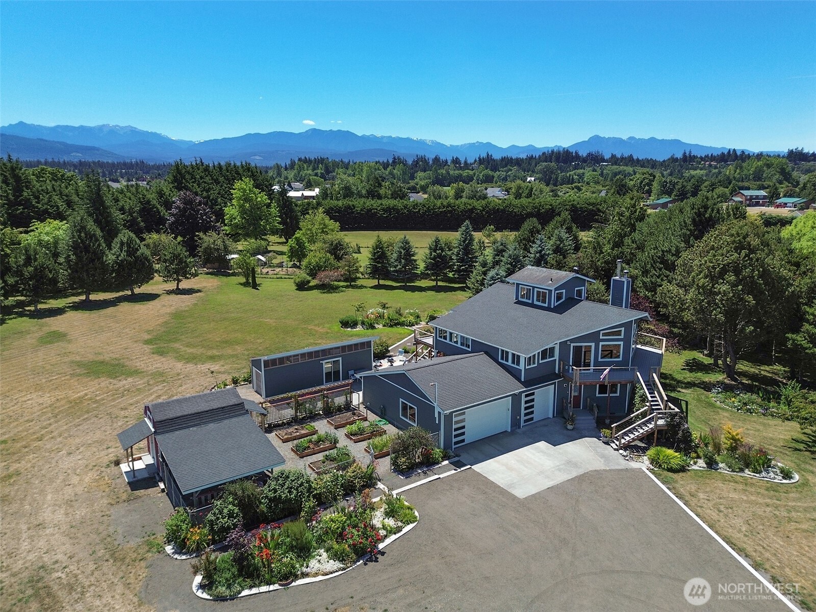 an aerial view of a house with a garden and lake view