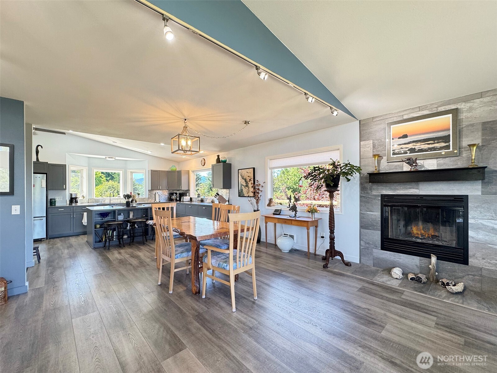 866 Jamestown Road Sequim, WA 98382 - Photo 11 of 40 a living room with furniture a fireplace and a dining table with wooden floor