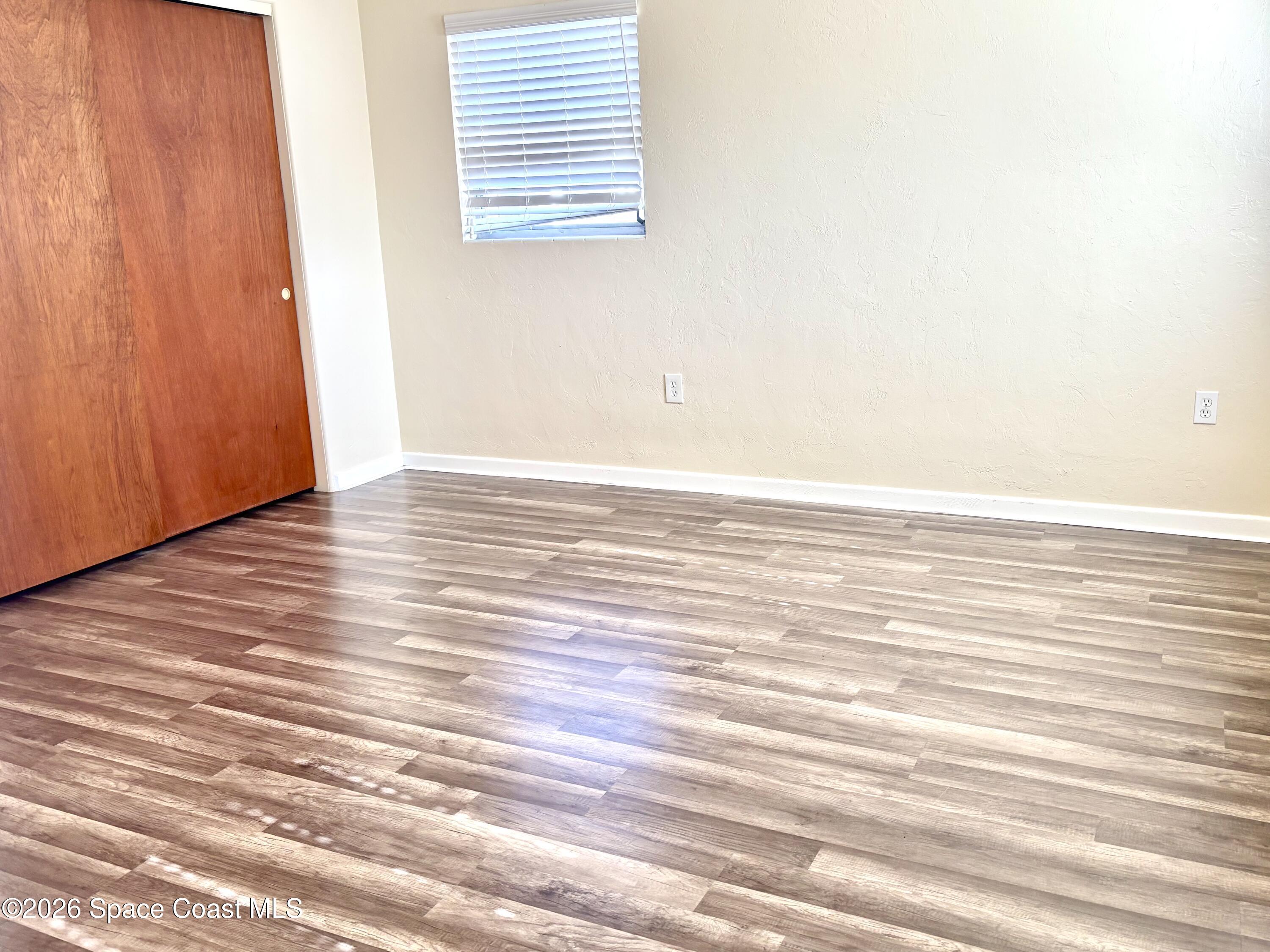 19 Orange Avenue Rockledge, FL 32955 - Photo 15 of 25 an empty room with wooden floor and windows
