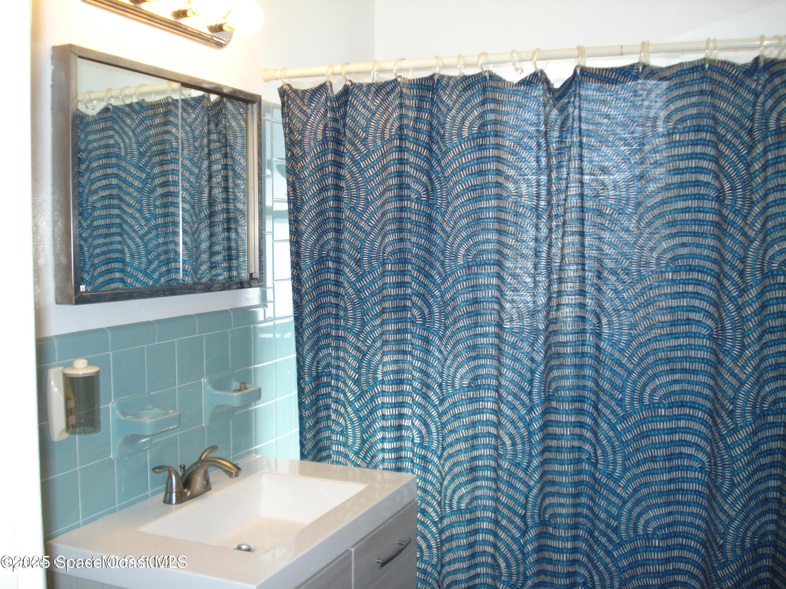 19 Orange Avenue Rockledge, FL 32955 - Photo 21 of 25 a bathroom with a sink and a mirror