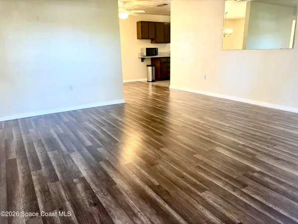 a view of empty room with wooden floor