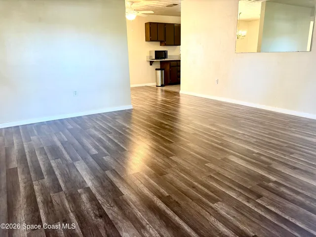 a view of empty room with wooden floor