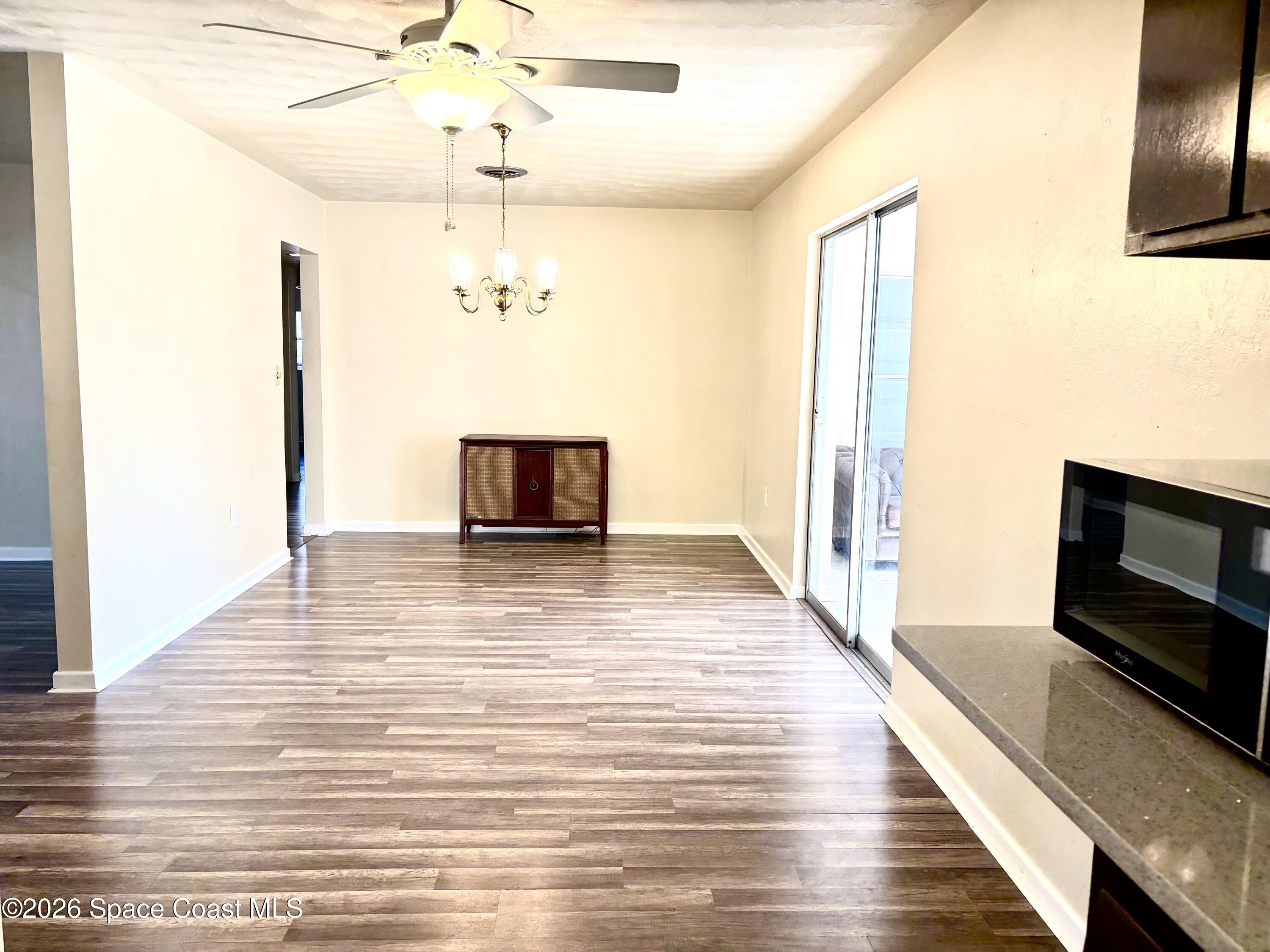19 Orange Avenue Rockledge, FL 32955 - Photo 6 of 25 a view of a livingroom with a fireplace a ceiling fan and wooden floor