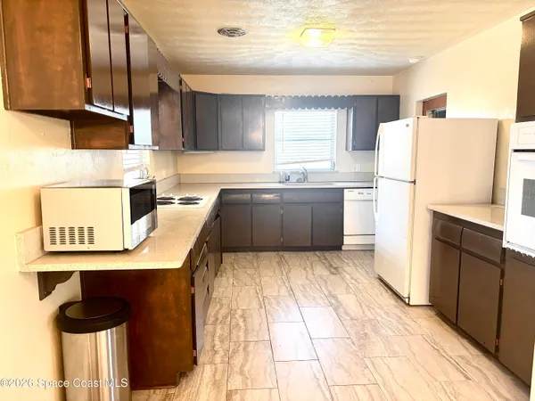 a kitchen with granite countertop a refrigerator and a stove top oven