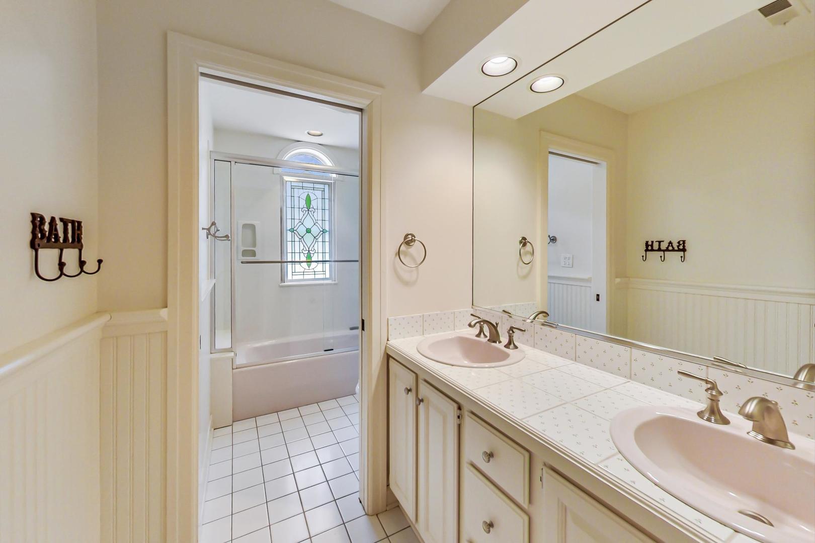 150 Firth Road Inverness, IL 60067 - Photo 64 of 83 a bathroom with a granite countertop sink a mirror a bathtub and shower