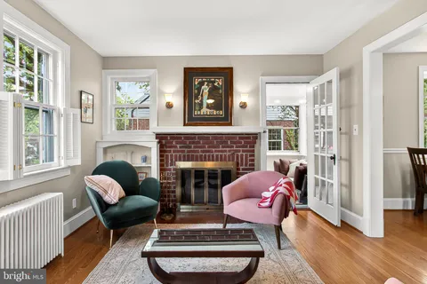 a living room with furniture a rug a fireplace and windows