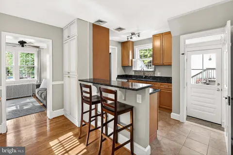 a kitchen with a table chairs refrigerator and cabinets
