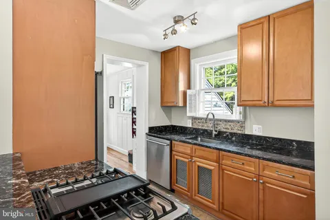 a kitchen with granite countertop stainless steel appliances a stove cabinets and sink