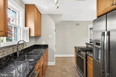 a kitchen with granite countertop a sink stove and refrigerator
