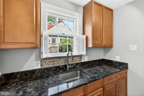 a kitchen with stainless steel appliances granite countertop a sink stove and cabinets