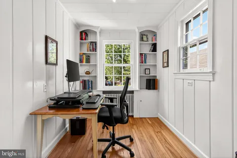 a view of a workspace with furniture and a window