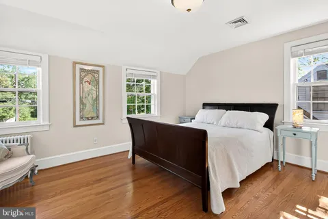 a bed sitting in a bedroom next to a window