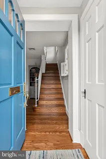 a view of a hallway with wooden floor and staircase