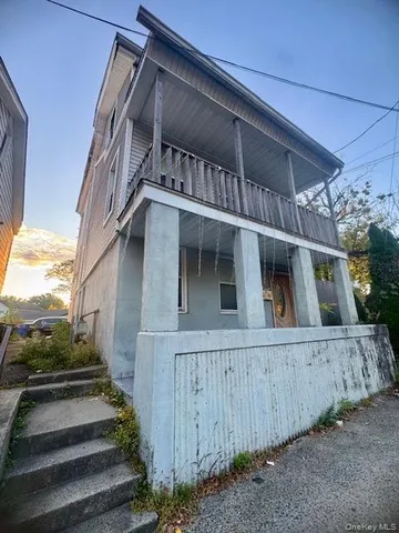 a view of a house with wooden fence and two windows