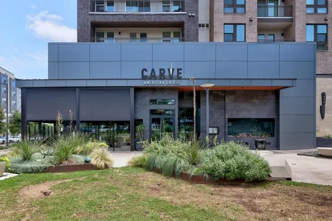 a front view of a building with a garden and plants