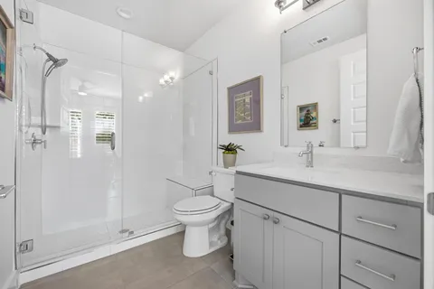a bathroom with a sink toilet a mirror and shower