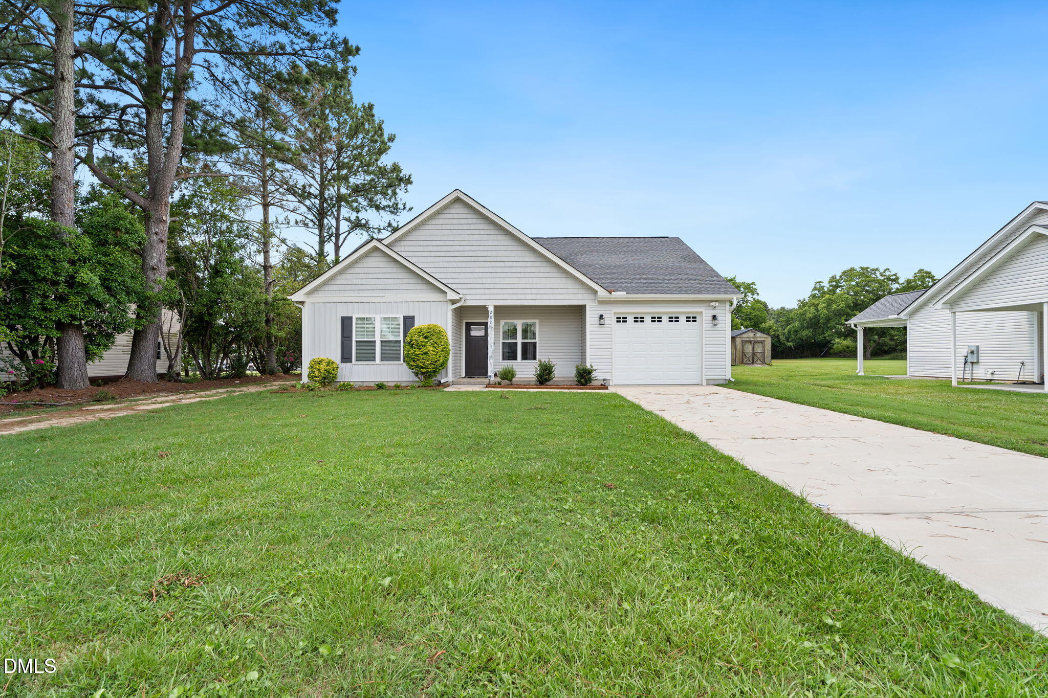 202 South 6th Street Erwin, NC 28339 - Photo 1 of 35 a view of a white house in front of a big yard with large trees