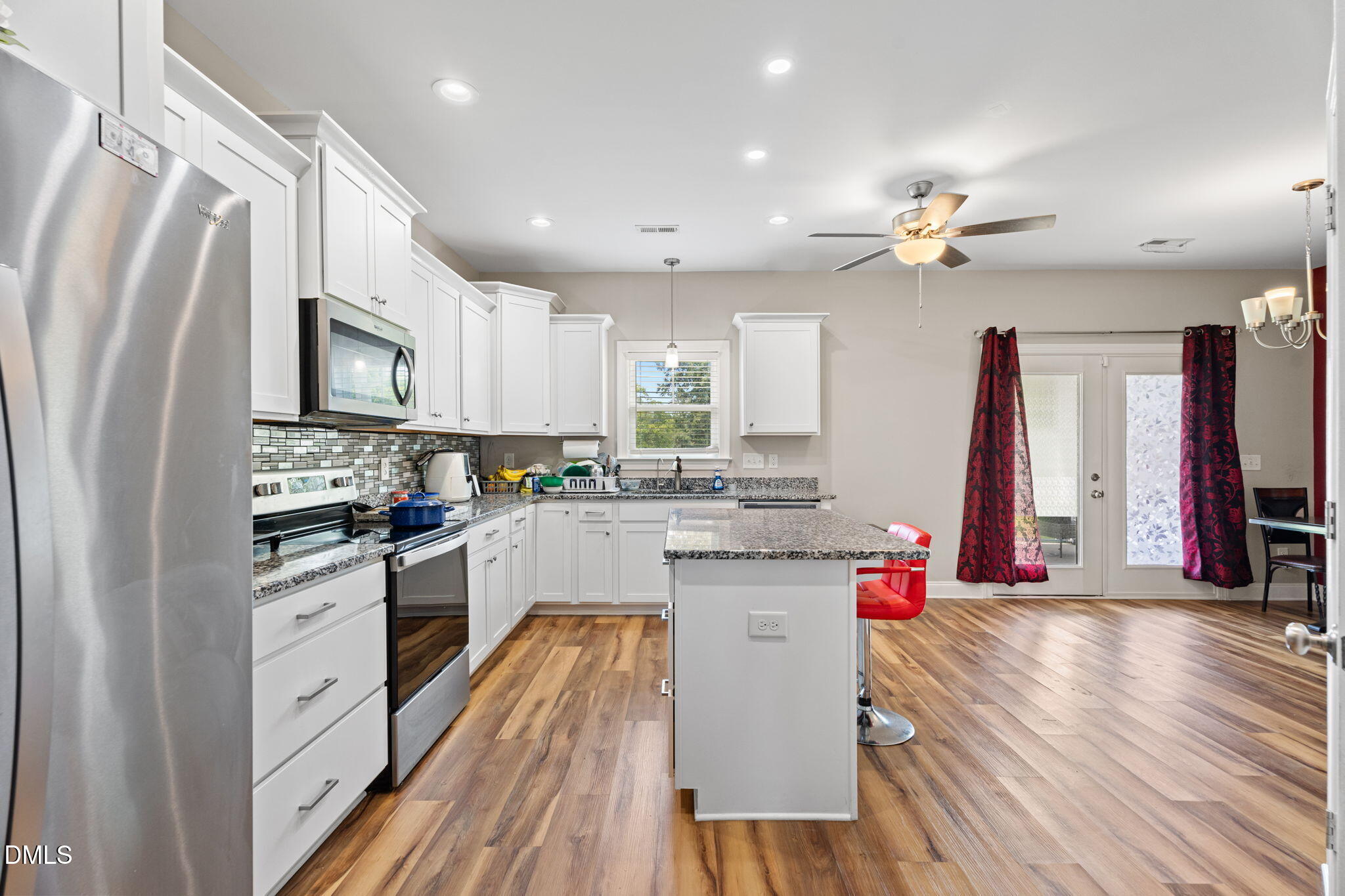 202 South 6th Street Erwin, NC 28339 - Photo 11 of 35 a kitchen with stainless steel appliances kitchen island granite countertop a stove a sink and a refrigerator