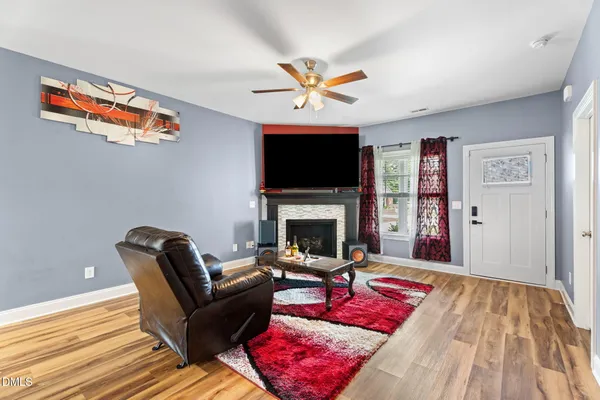 a living room with furniture a flat screen tv and a fireplace