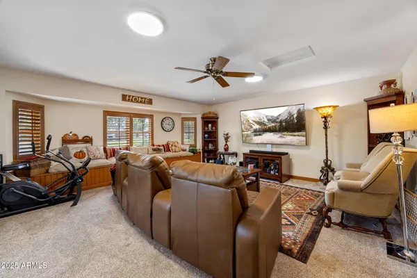 a living room with furniture ceiling fan and a window
