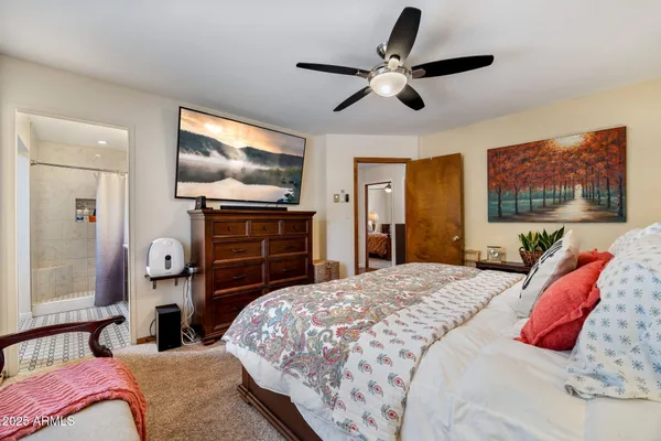 a bedroom with a large bed and a flat tv screen