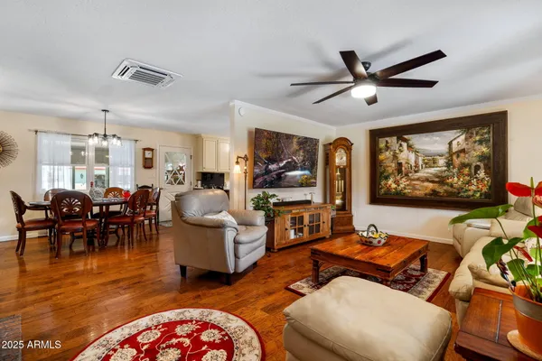 a living room with furniture kitchen view and a large window
