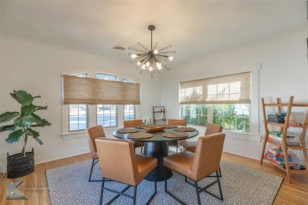 a dining room with furniture potted plants and wooden floor