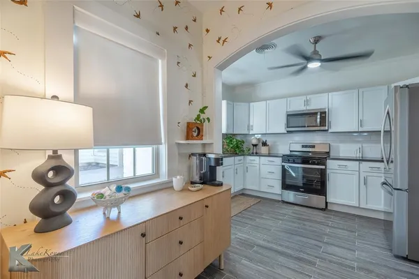 a kitchen with white cabinets and appliances