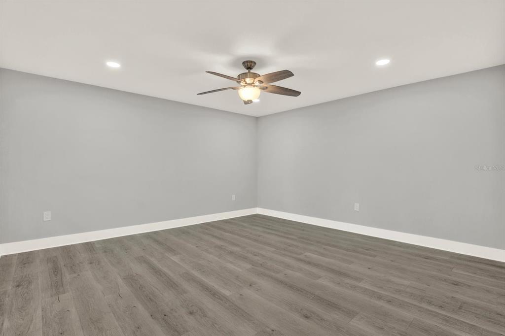 337 Rex Place, Unit A Madeira Beach, FL 33708 - Photo 17 of 48 a view of a room with wooden floor and a ceiling fan