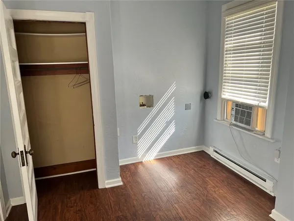 an empty room with wooden floor and a window
