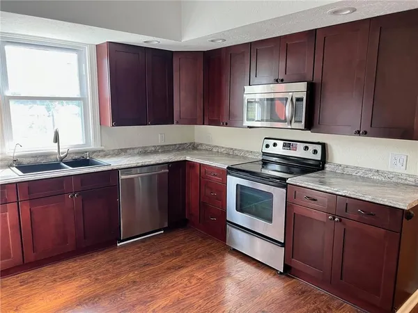 a kitchen with wooden cabinets and stainless steel appliances