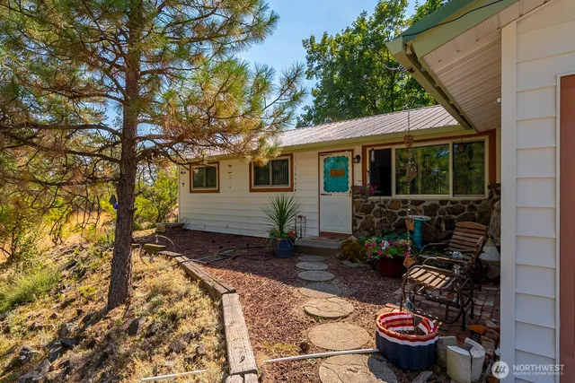a view of a backyard with table and chairs and wooden fence