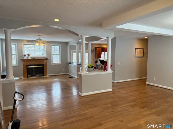 an empty room with wooden floor and fireplace