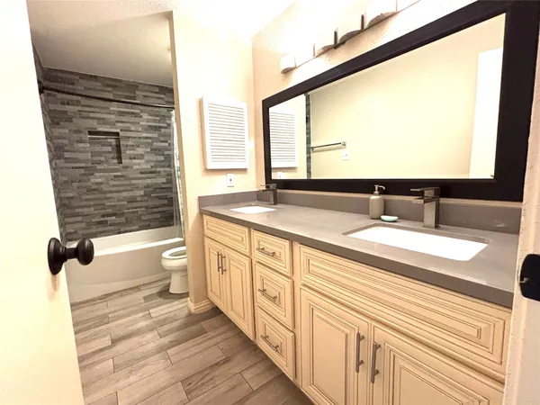 a bathroom with a granite countertop sink and a large mirror