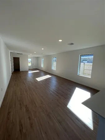a view of empty room with wooden floor and window