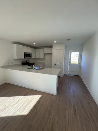 an empty room with wooden floor and cabinet