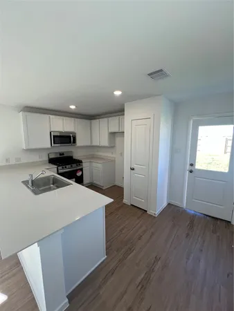 a kitchen with wooden cabinets and stainless steel appliances