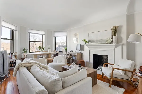 a living room with furniture a fireplace and windows