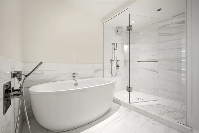 a white bath tub sitting next to a shower