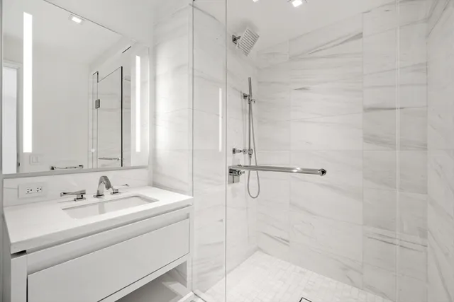 a bathroom with a sink a mirror and shower