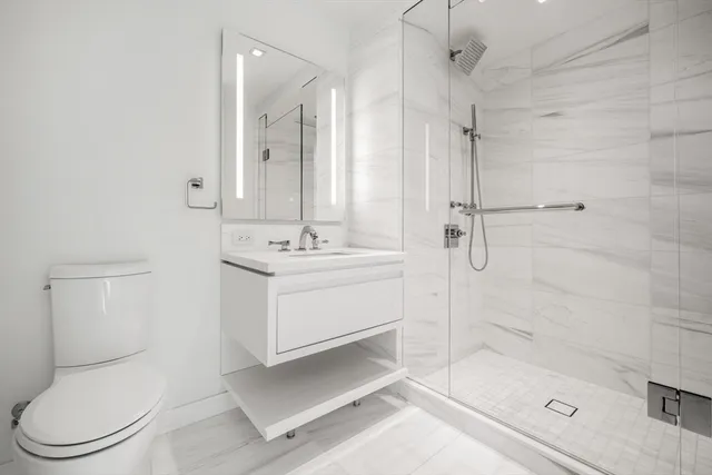 a bathroom with a sink a toilet and shower