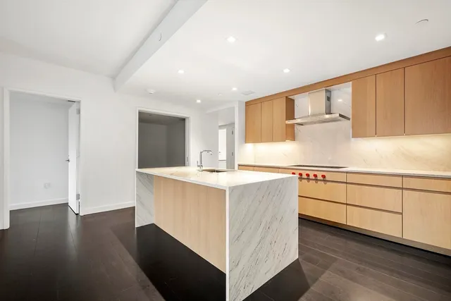 a kitchen with cabinets stove and wooden floor