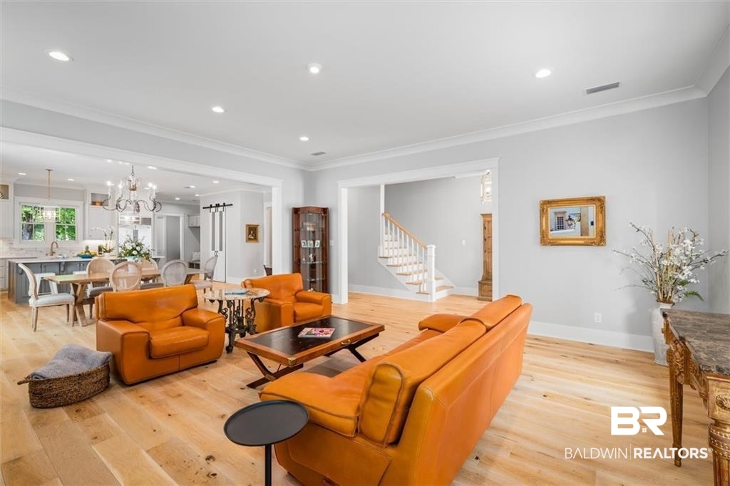 707 Cardamel Court Fairhope, AL 36532 - Photo 6 of 40 Living room with light hardwood / wood-style floors, a notable chandelier, and crown molding