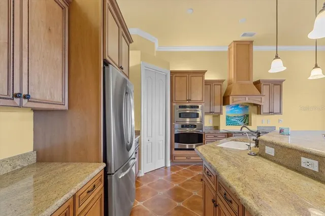 a kitchen with stainless steel appliances granite countertop a sink a stove and a refrigerator