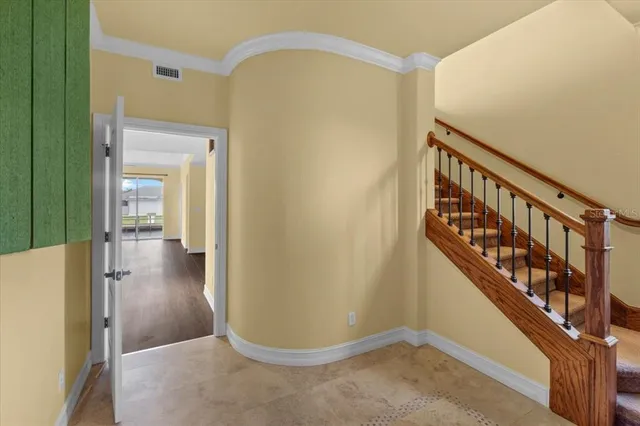 a view of a hallway with wooden floor and staircase