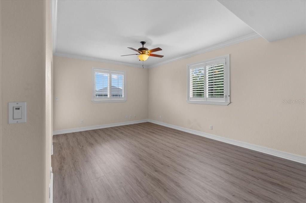 4301 Vasco Street Punta Gorda, FL 33950 - Photo 9 of 53 an empty room with wooden floor ceiling fan and windows