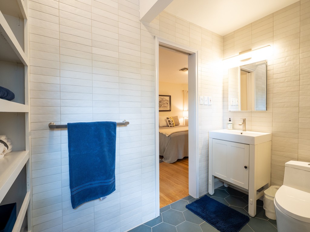 4617 Finley Drive Austin, TX 78731 - Photo 17 of 36 Ensuite bathroom featuring tile walls, dark tile patterned flooring, and vanity