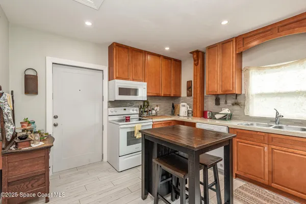 a kitchen with stainless steel appliances granite countertop a stove a sink a microwave a refrigerator and cabinets