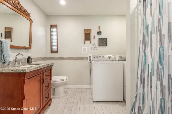 a bathroom with a granite countertop sink toilet and mirror